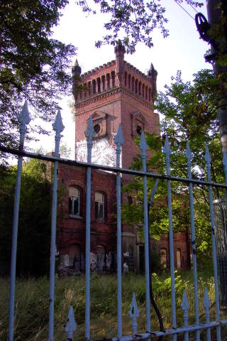 Abandoned castle-like building behind a fence